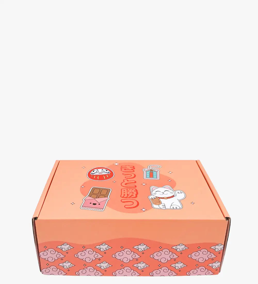 Koraalroze kartonnen doos met schattige Japanse thema's illustraties, waaronder een witte gelukskat, een daruma-bal en chocoladereepontwerpen.