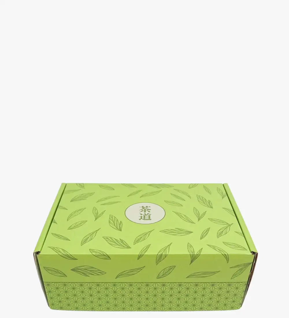 Lichtgroene kartonnen doos versierd met een herhalend bladpatroon en met de Chinese karakters '茶道' in een centraal cirkelvormig embleem.